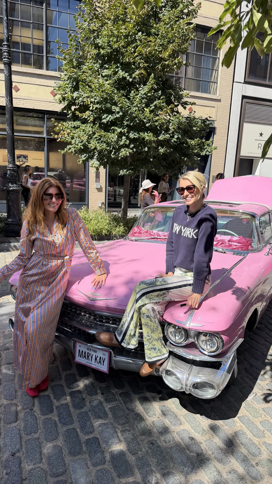 Event content: Kristin posing on a pink vintage car at the Mary Kay NYC pop-up