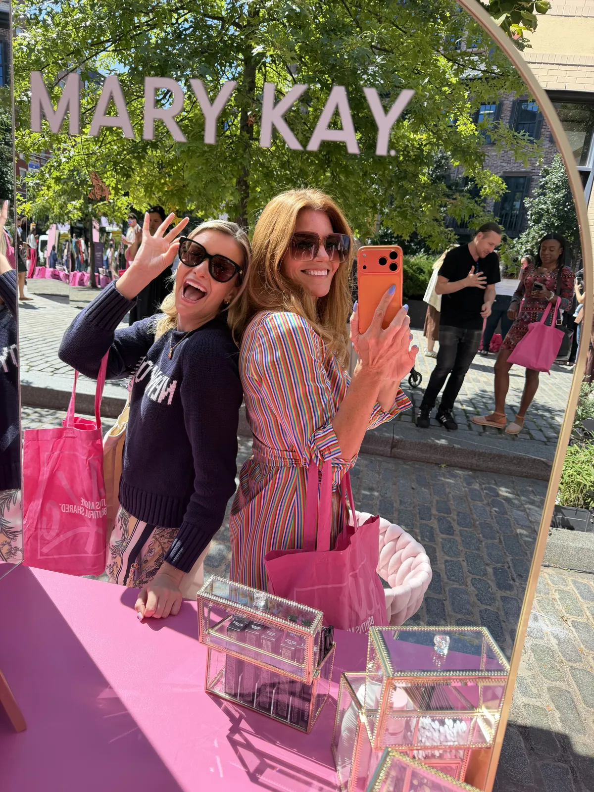 Event content: Kristin and Emily at the Mary Kay NYC pop-up sign in SoHo